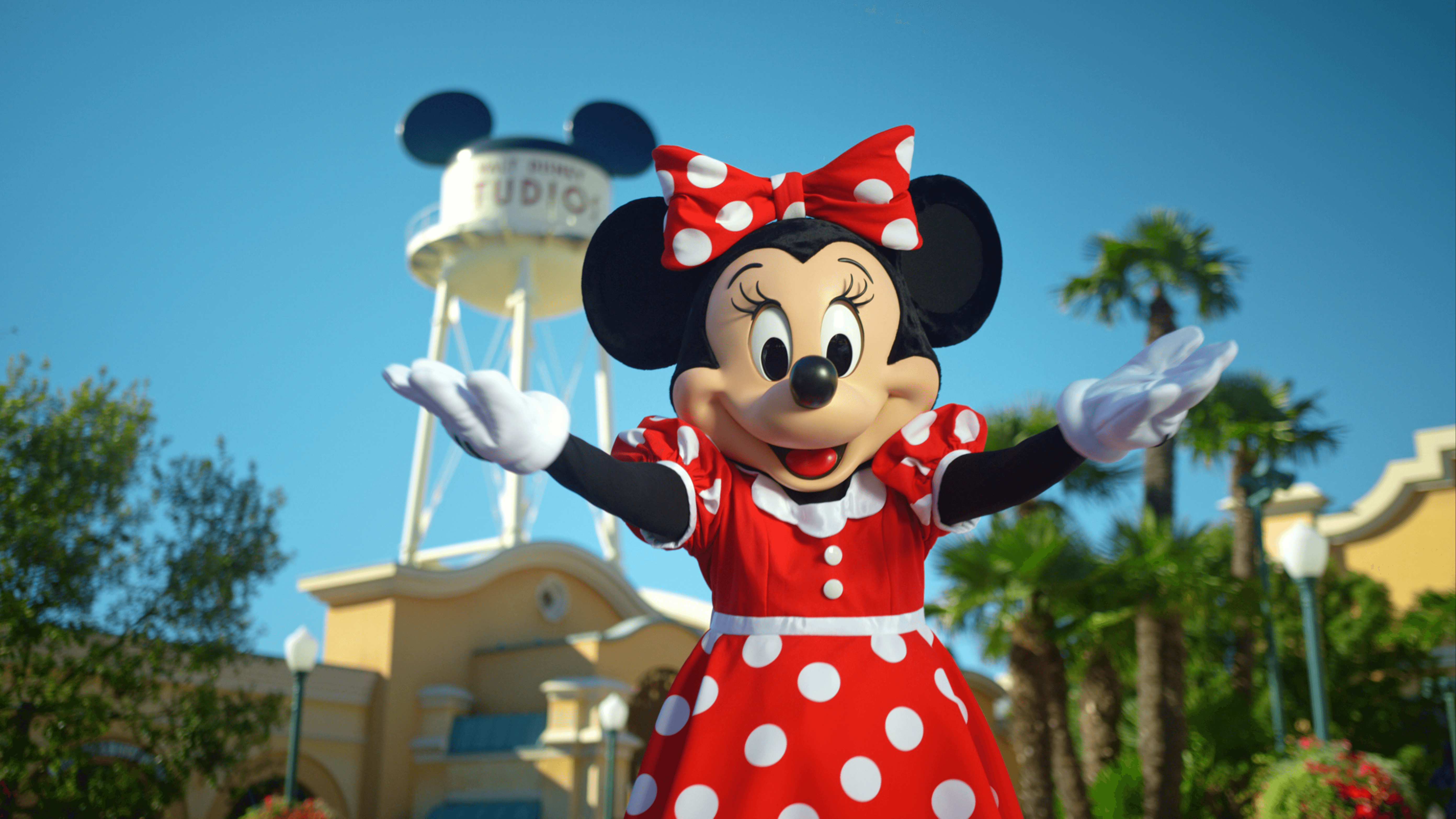 Minnie Mouse waving in front of the Walt Disney Studios® Park water tower sign